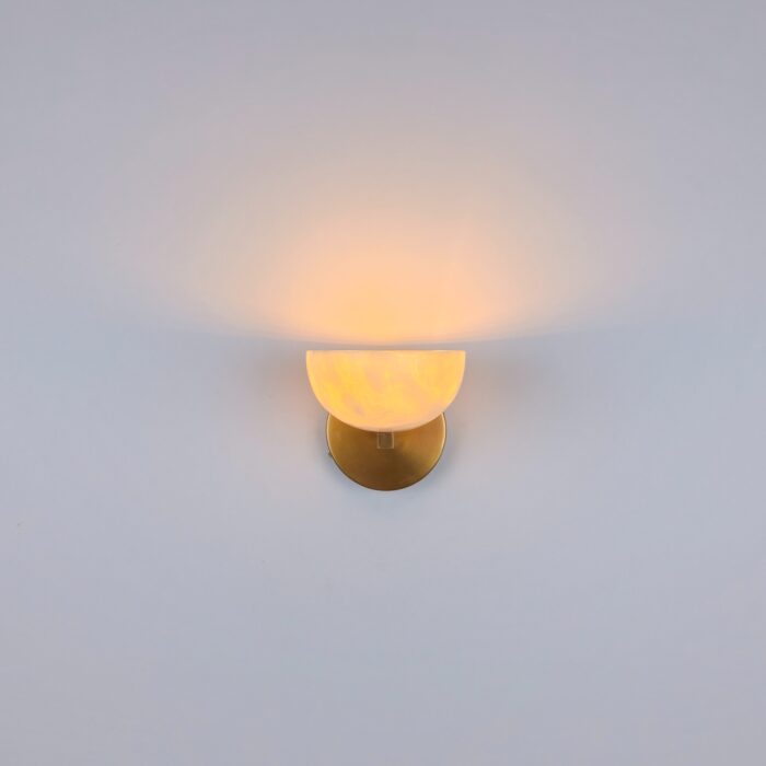 Handmade Alabaster Wall Light featuring a natural translucent white alabaster stone shade mounted on a round solid brass base. This sophisticated wall sconce provides a warm, soft ambient glow, perfect for upscale modern interior décor.